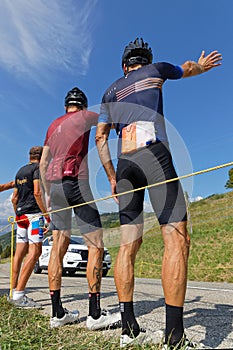 Three spectators and advertsing caravan on the Tour de France