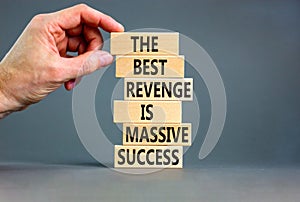 Revenge or success symbol. Concept words The best revenge is massive success on wooden blocks. Bussinesman hand. Beautiful grey