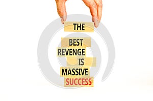 Revenge or success symbol. Concept words The best revenge is massive success on wooden blocks. Bussinesman hand. Beautiful white