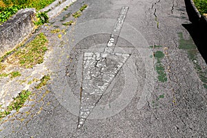 Reverse direction arrow on a weathered asphalt road