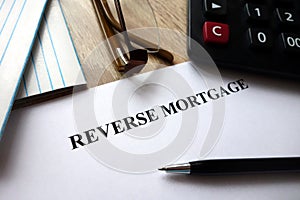 Reverse mortgage document with pen, calculator and glasses