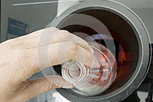 Reverse vending machine in shopping mall. Woman hand put empty plastic bottle in the machine. Reverse vending machine