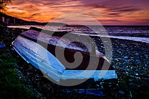 Reversed Fishermen Rowboat On Sunset Shore