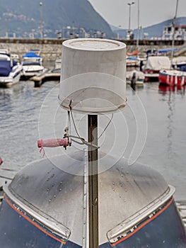 Reversed plastic bucket over a turned boat in harbor.