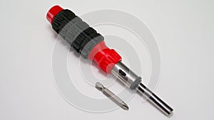 Reversible screwdriver with nozzle. On a white background. Universal tool for a twist
