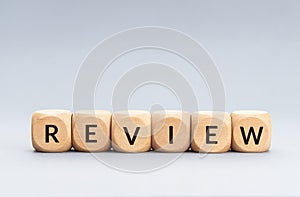 Review word on wooden blocks on gray background