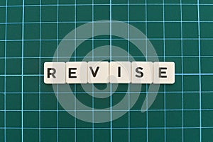 Revise word made of square letter word on green square mat background