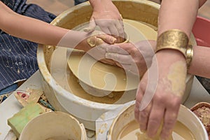 Revival of folk crafts. Shaping clay on pottery wheel. Creative lesson. Teacher and child