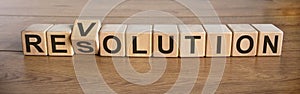 Revolution or resolution words on wooden cubes in brown background. Concept
