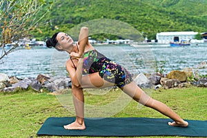 revolved side angle pose or parivrtta parsvakonasana yoga with ukrainian woman making it outdoors