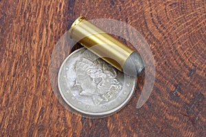 Revolver cartridges and Silver Dollar Wild West period on wooden background