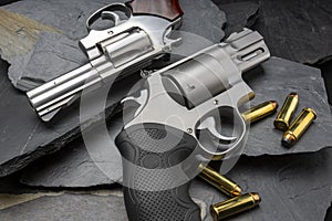 Revolver handguns on black stone background