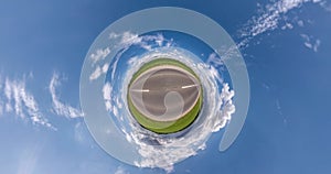 Revolves on road among fields with beautiful clear sky and white clouds. Little planet Transformation with curvature of space. loo