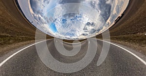 Revolves on road among fields with beautiful sky with gray clouds. Little planet Transformation with curvature of space. loop rota