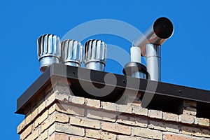 Revolving cowls on a rooftop eradicate downdraught in chimneys