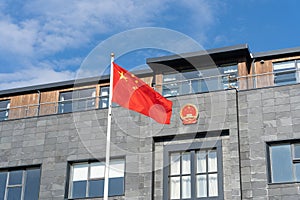 Chinese flag and coat of arms at Chinese embassy building in Reykjavik, Iceland