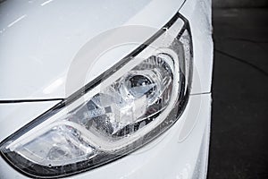 An RFID tag sticker on the headlight of a pearl white car