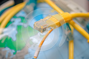 RG-45 plug is a close-up. Terminal end on the background of the globe. The concept of global communication on earth. Server photo
