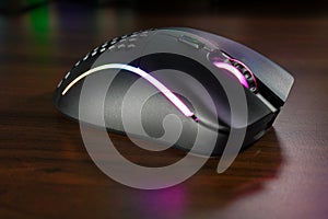 RGB Gaming mouse with colorful light reflections on the table