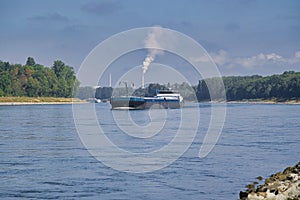 RHEIN, GERMANY - September 2022: A beautiful shot of the cargo ship on the Rhine river near Mannheim in bright sunlight