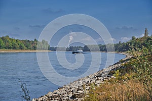 RHEIN, GERMANY - September 2022: A beautiful shot of the cargo ship on the Rhine river near Mannheim in bright sunlight