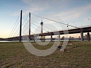 The Rheinknie bridge and the Rheinturm tower in the city of Dusseldorf. View of the city skyline from the bank of the river Rhine. photo