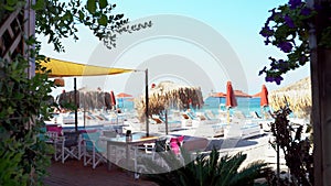 Rhodes, Greece: Entrance to a main beach of mediterranean sea through restaurant with white chairs