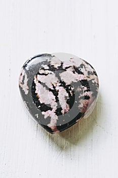 Rhodonite stone heart on a white background