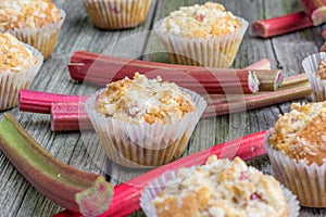 Rhubarb muffin in paper cups with rhubarb petioles in the background