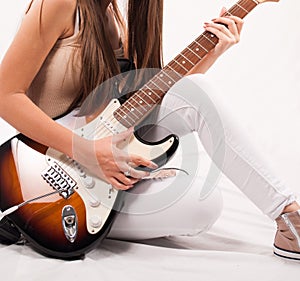 Rhythm and Melody: Young Woman Captivating with her Guitar - Close-Up Studio Shot