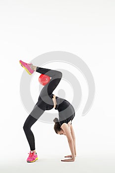 Rhythmic gymnast with ball in studio