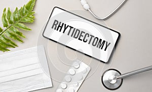 Rhytidectomy word on smartphone,stethoscope and green plant
