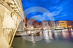 Rialto Bridge at night with city restaurants along grand canal, Venice, Italy