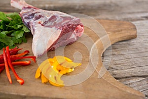 Rib chop, bell pepper and corainder leaves on wooden tray against wooden background