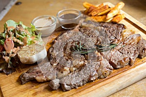 Rib Eye Steak in wooden plate on the wood table in restaurant
