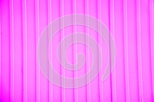 Ribbed wall of the shipping container. Pink corrugated metal sheet useful as a background, horizontal image.