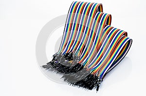 Ribbon cable or multi-wire planar cable on white background. Flat ribbon cable with pin connectors. Multi-colored ribbon computer