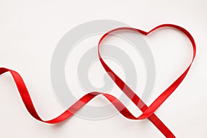 Red ribbon heart love symbol. Happy Valentine's day. White background with copyspace