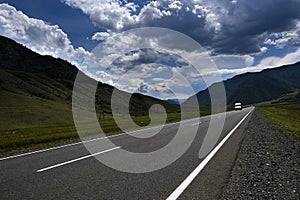 ribbon of the road among the slopes of the mountains on the expanses of Altai on a summer day