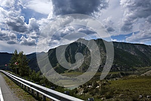 ribbon of the road among the slopes of the mountains on the expanses of Altai on a summer day