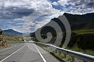 ribbon of the road among the slopes of the mountains on the expanses of Altai on a summer day