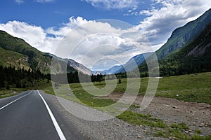ribbon of the road among the slopes of the mountains on the expanses of Altai on a summer day