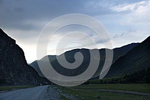 ribbon of the road among the slopes of the mountains on the expanses of Altai on a summer day