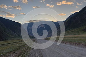 ribbon of the road among the slopes of the mountains on the expanses of Altai on a summer day