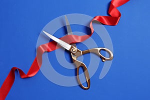 Ribbon and scissors on color background. Ceremonial red tape cutting