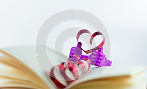 Ribbons shaped as hearts in a book for your text on white background