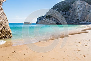 Ribeiro do Cavalo Beach with clear turquoise water with rocks and a ball floating in the water, Sesimbra PORTUGAL photo