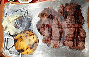 Ribeye steak with baked potato and vegetables