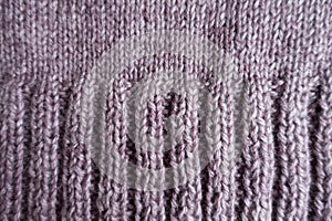 Ribs on the edge of puce knitted fabric photo