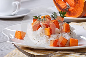 Rice with baked pumpkin and parsley on the plate.